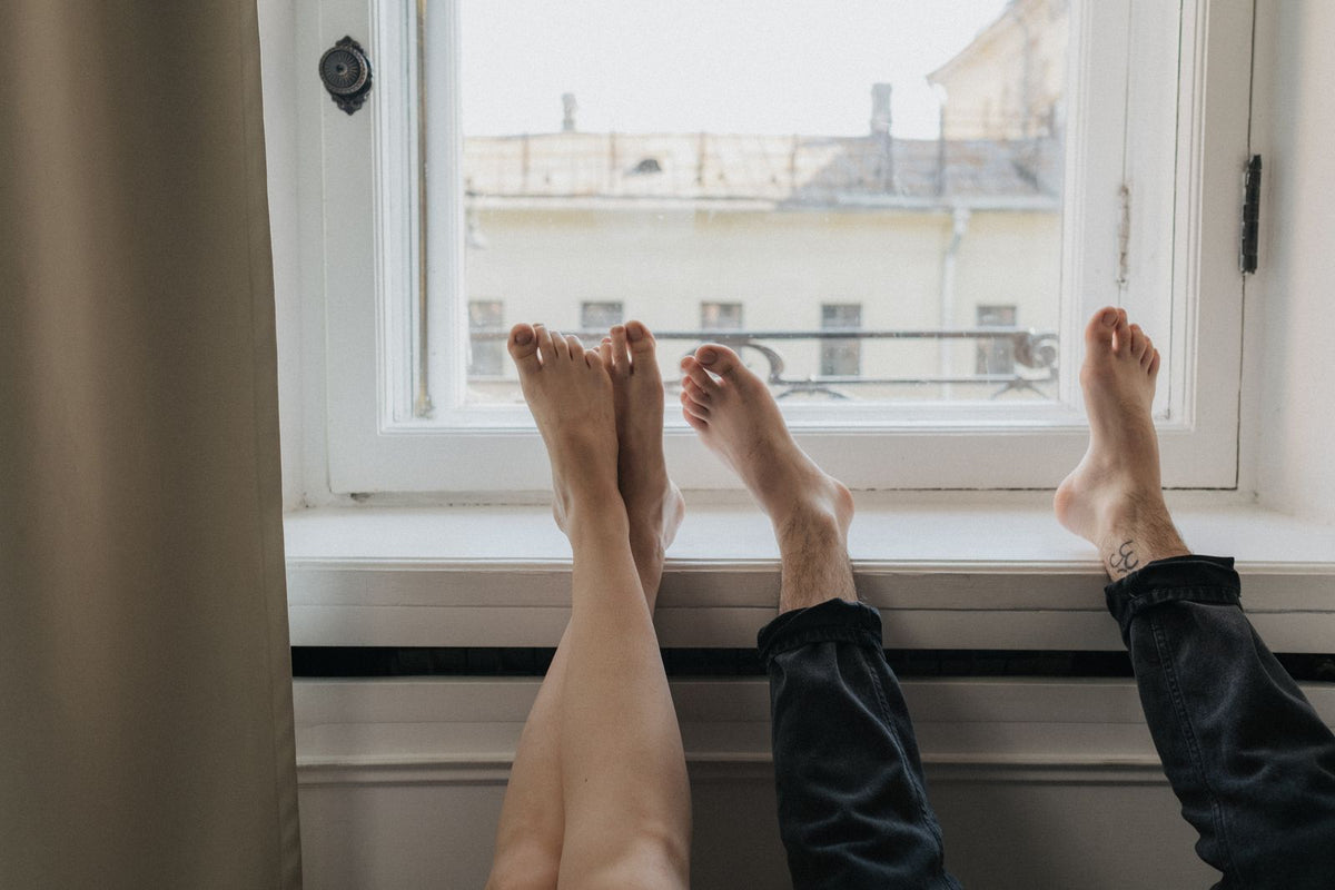 Piernas descansando en alto sobre el alféizar de una ventana